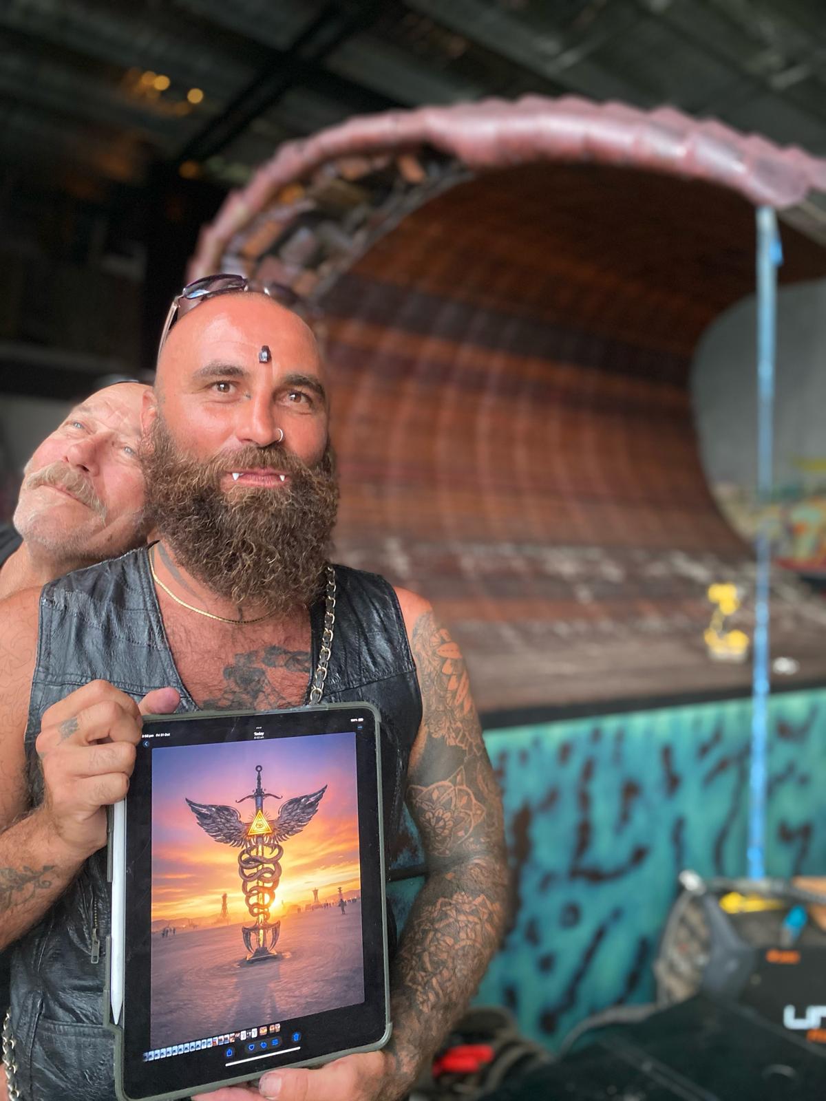 Jai, the artist behind For They Know Not What They Do, holding a tablet showing the sculpture concept